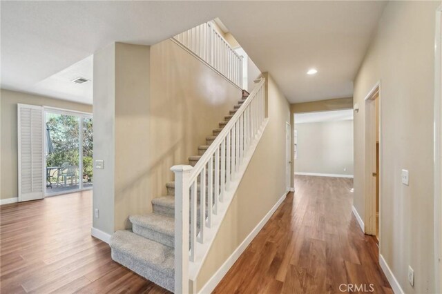 staircase with hardwood / wood-style floors