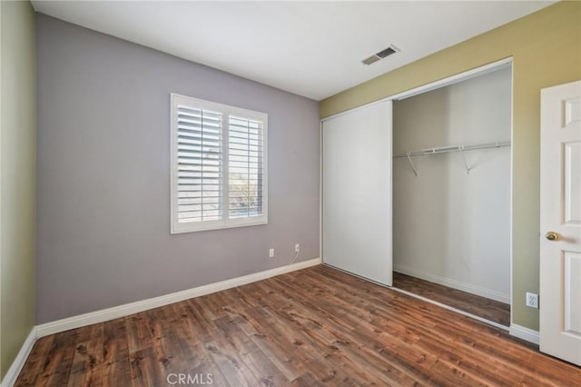 unfurnished bedroom featuring dark wood-type flooring and a closet