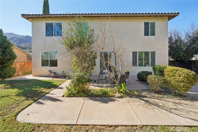 view of front of property with a mountain view and a patio area