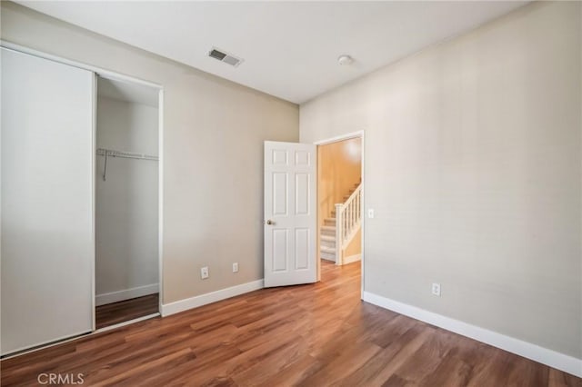 unfurnished bedroom featuring hardwood / wood-style floors and a closet