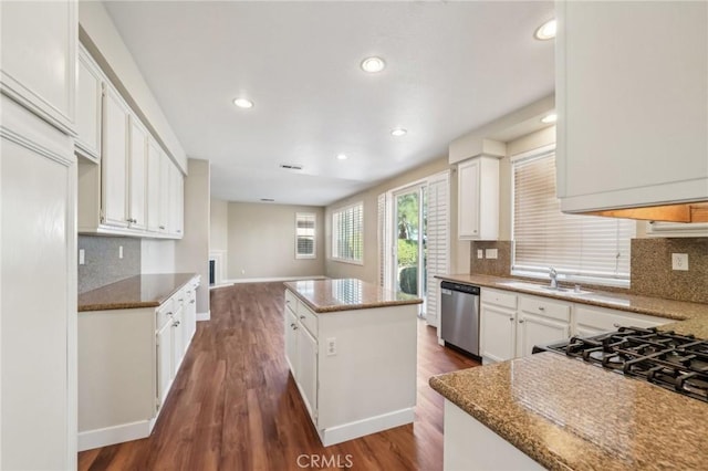 kitchen featuring sink, white cabinetry, dishwasher, stone counters, and a kitchen island