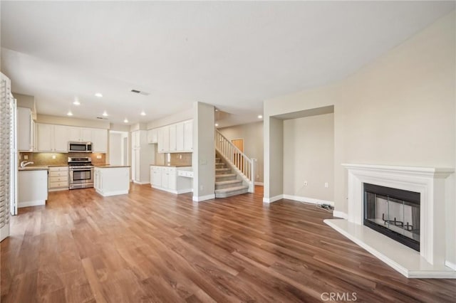 unfurnished living room with hardwood / wood-style flooring and sink