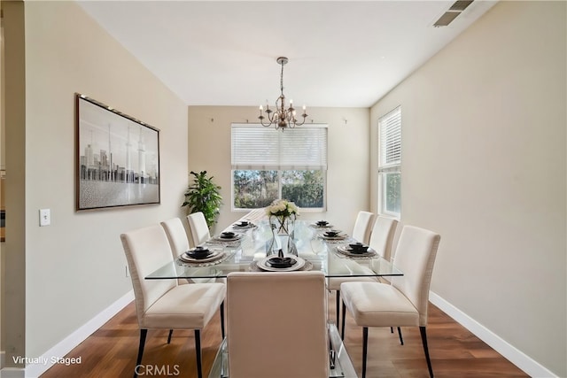 dining area featuring dark wood-type flooring and a chandelier