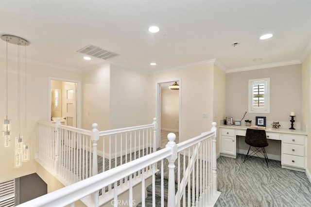 interior space with built in desk, crown molding, and light colored carpet