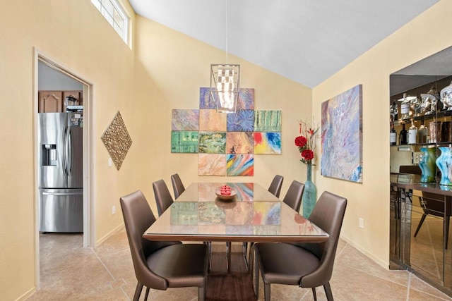 dining area featuring lofted ceiling and light tile patterned floors