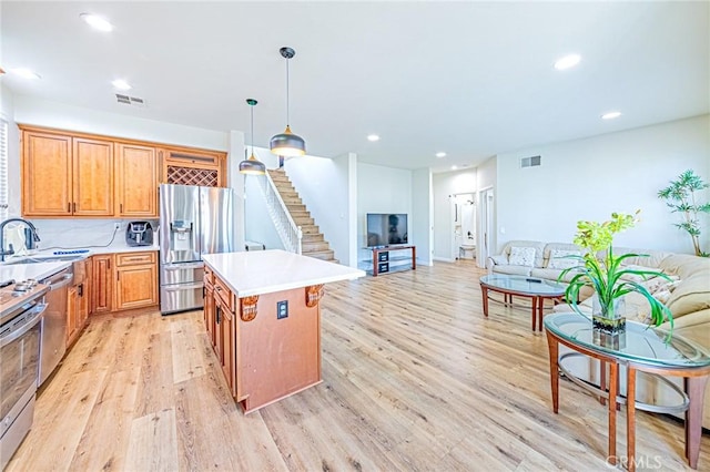 kitchen featuring light hardwood / wood-style flooring, pendant lighting, stainless steel appliances, tasteful backsplash, and a kitchen island