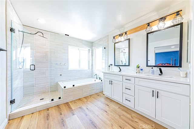 bathroom featuring hardwood / wood-style flooring, independent shower and bath, and vanity