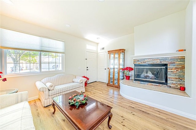 living room featuring hardwood / wood-style floors and a stone fireplace