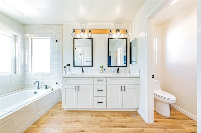 full bathroom featuring toilet, separate shower and tub, wood-type flooring, and vanity