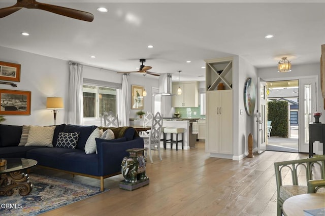 living room with ceiling fan and light hardwood / wood-style flooring