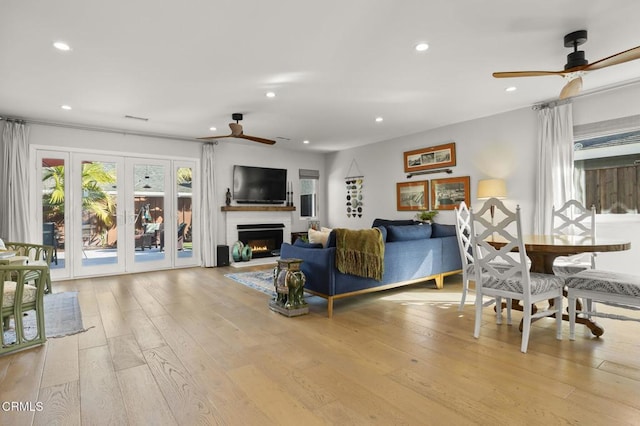 living room featuring ceiling fan and light hardwood / wood-style flooring