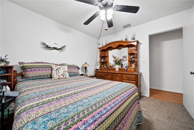 bedroom featuring ceiling fan, carpet flooring, and a textured ceiling