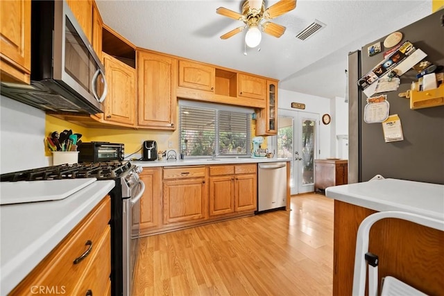 kitchen with sink, ceiling fan, stainless steel appliances, french doors, and light wood-type flooring