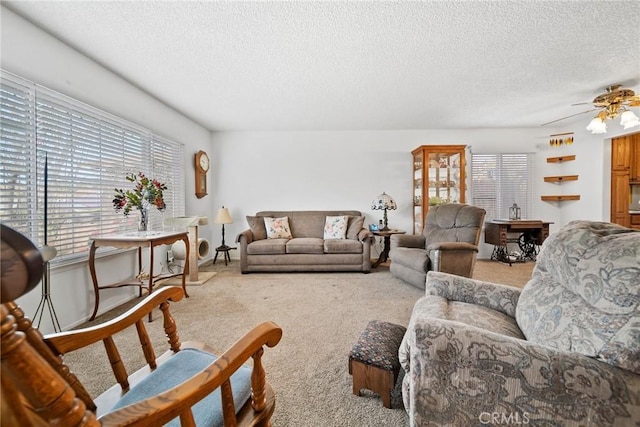 living room with ceiling fan, carpet, and a textured ceiling