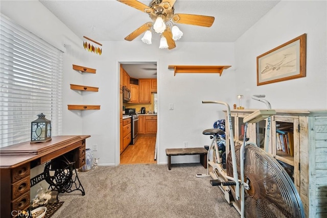 workout room featuring ceiling fan and light carpet