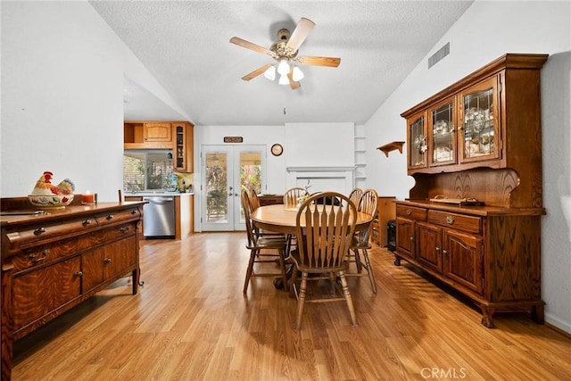 dining area featuring light hardwood / wood-style flooring, a textured ceiling, ceiling fan, and french doors