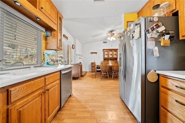 kitchen with lofted ceiling, sink, ceiling fan, appliances with stainless steel finishes, and light wood-type flooring