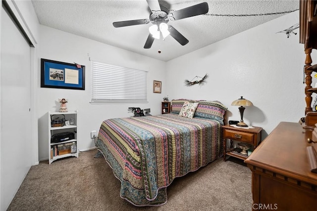 carpeted bedroom featuring ceiling fan, a closet, and a textured ceiling