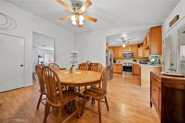 dining area with ceiling fan, a textured ceiling, and light hardwood / wood-style floors