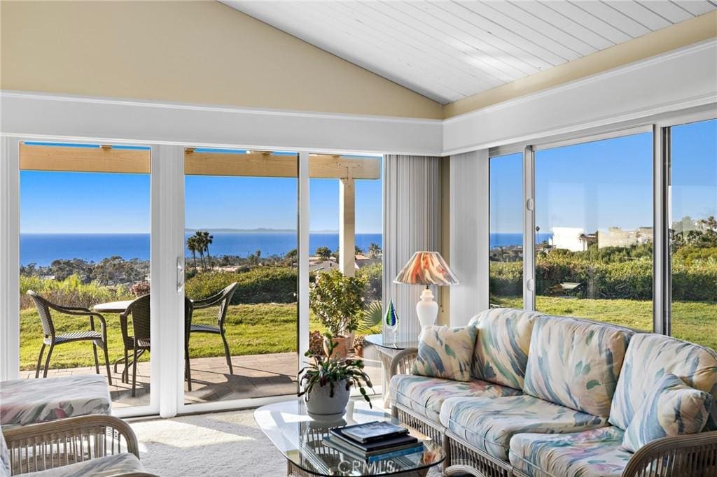 sunroom with a water view and lofted ceiling