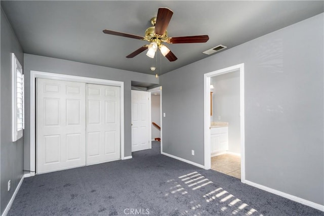 unfurnished bedroom with ceiling fan, light colored carpet, connected bathroom, and a closet