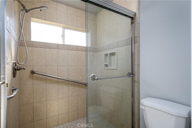 bathroom with toilet and a shower with door