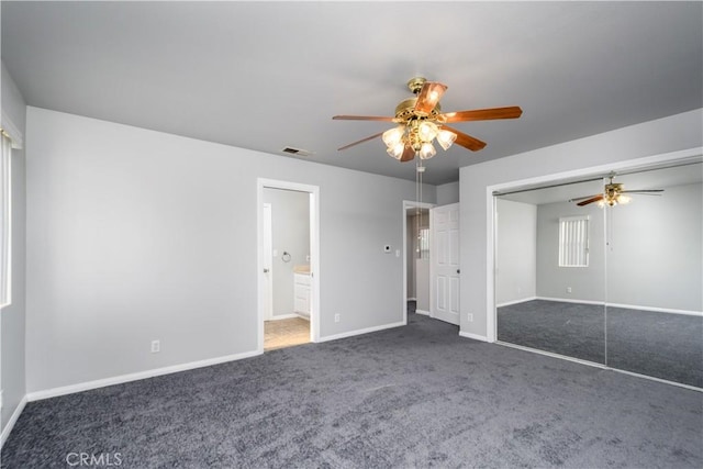 unfurnished bedroom with ceiling fan, a closet, and dark carpet