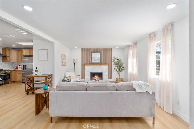 living room with light hardwood / wood-style floors and a premium fireplace