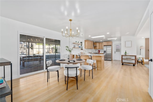 dining space featuring an inviting chandelier and light hardwood / wood-style flooring