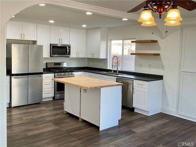 kitchen featuring sink, stainless steel appliances, a center island, white cabinets, and wood counters