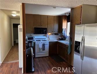 kitchen with a textured ceiling, dark hardwood / wood-style flooring, white gas stove, and stainless steel refrigerator with ice dispenser