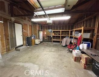 interior space featuring a garage door opener, water heater, and a workshop area