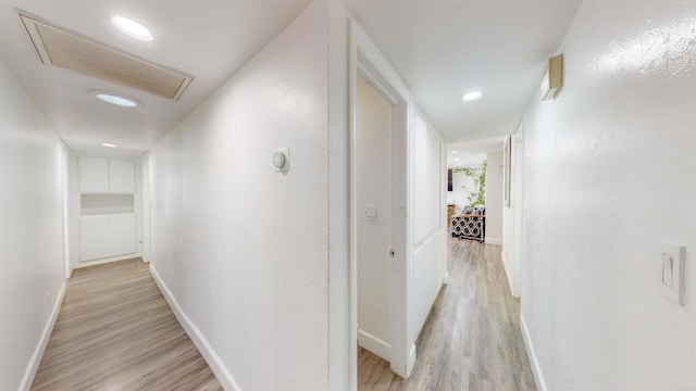 hallway with light wood-style floors, recessed lighting, and baseboards