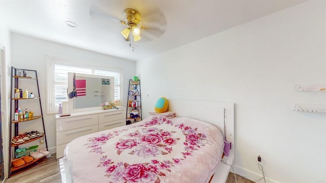 bedroom featuring light wood finished floors, ceiling fan, and baseboards