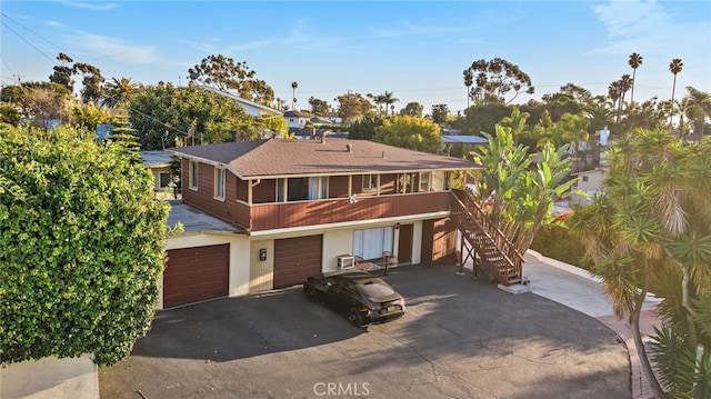 townhome / multi-family property featuring driveway, stairway, and an attached garage