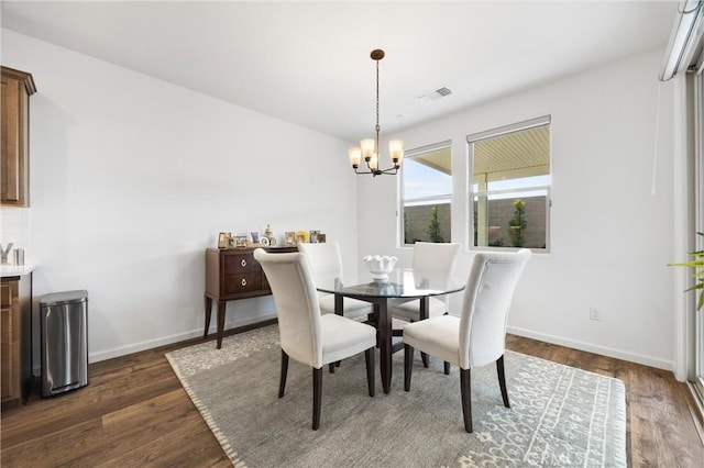 dining space featuring dark hardwood / wood-style flooring and a notable chandelier