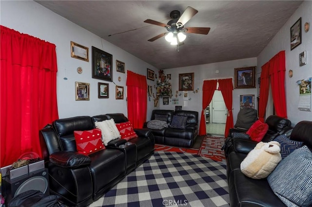 living room with ceiling fan and a textured ceiling