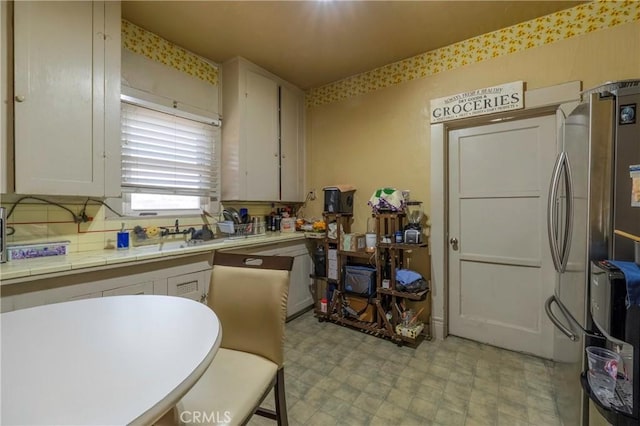 kitchen with white cabinetry and stainless steel refrigerator