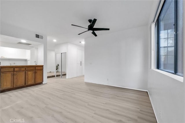 unfurnished living room with ceiling fan and light hardwood / wood-style floors