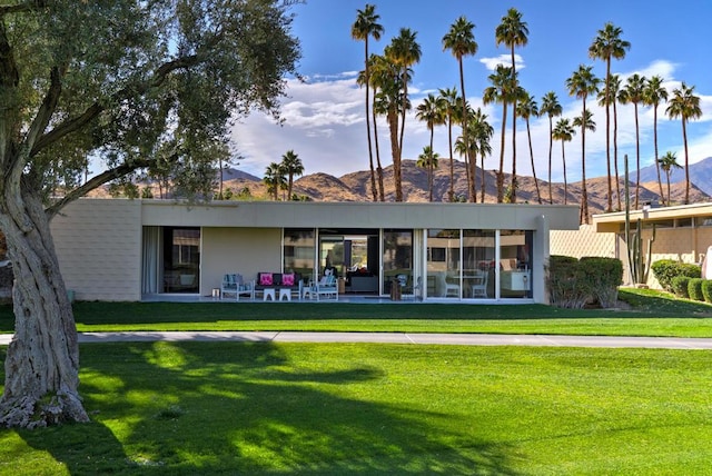 rear view of property with a yard and a mountain view