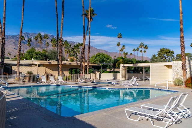 view of swimming pool with a patio and a mountain view