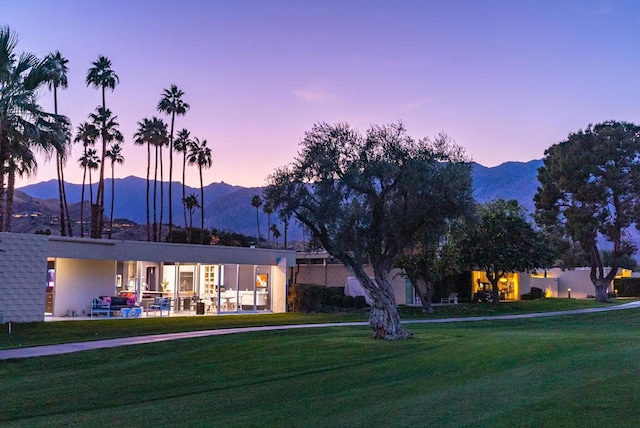 exterior space with a yard, a mountain view, and a patio area