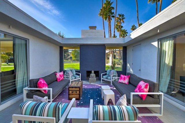 view of patio with an outdoor living space with a fireplace