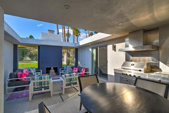 view of patio / terrace with an outdoor living space with a fire pit, a grill, and an outdoor kitchen