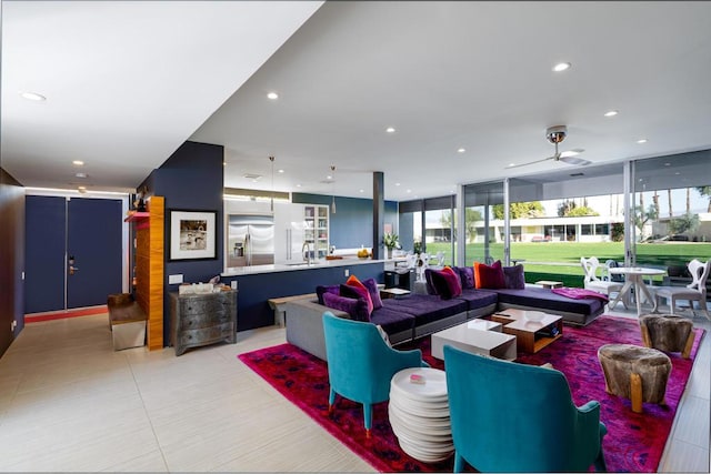 living room with sink, ceiling fan, and expansive windows