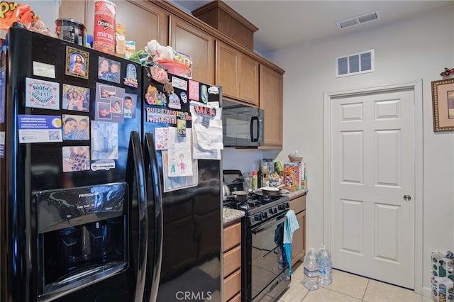 kitchen with light tile patterned flooring and black appliances