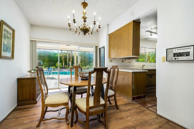 dining space featuring a textured ceiling, dark hardwood / wood-style floors, and a chandelier