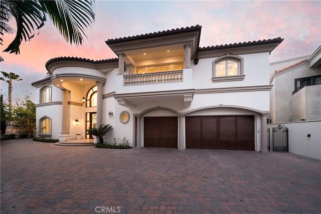 mediterranean / spanish-style house with a garage and a balcony