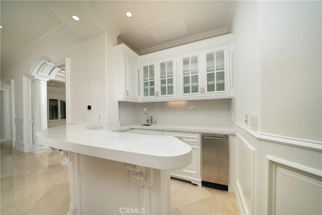 kitchen featuring kitchen peninsula, sink, ornamental molding, white cabinets, and a breakfast bar area