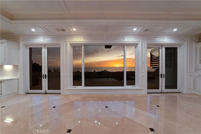 empty room featuring ornamental molding, french doors, and coffered ceiling